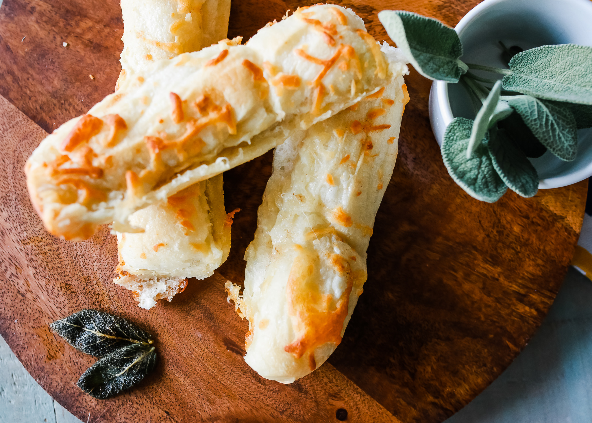 Cheesy breadsticks with a subtle delicious brown butter and sage flavoring. Easy breadsticks to make using frozen real yeast roll dough.